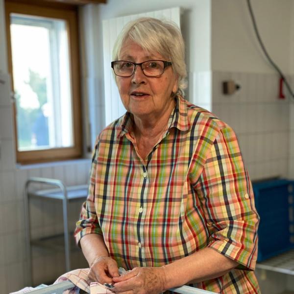 ältere Frau vor Abwaschmaschine