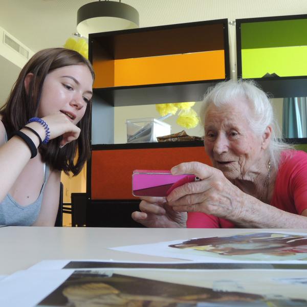 Eine Schülerin tauscht sich mit einer dementen Frau über ein Foto aus.